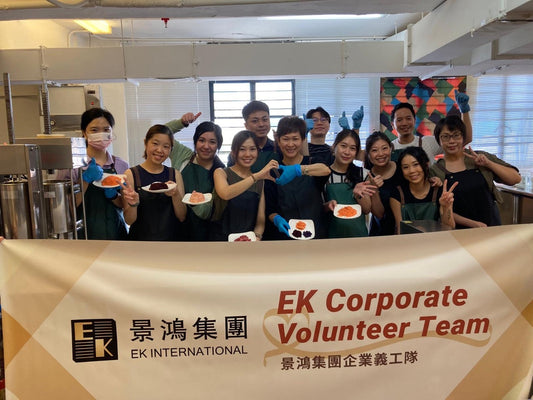EK Immigration Corporate volunteers preparing fresh pet food donations in collaborative workshop setting