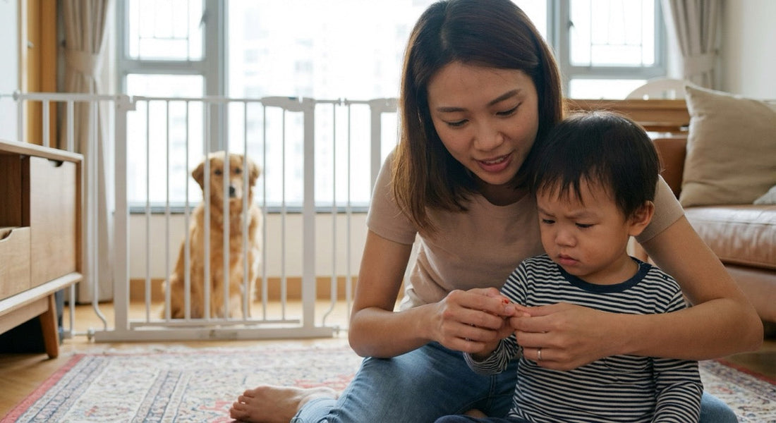 A Hong Kong mother calmly checking her toddler’s hand after a dog bite while the family dog is safely separated behind a baby gate.